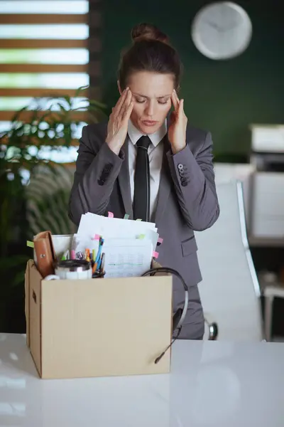 新しい仕事 ダンボール箱の個人的な持ち物が付いている灰色のビジネス スーツの現代緑のオフィスの現代女性の従業員を懸念して下さい — ストック写真