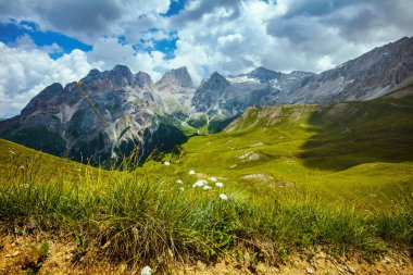 Dolomitlerde yaz zamanı. Dağlı, tepeli, bulutlu ve otlu manzara.