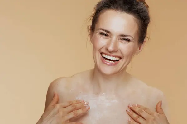 Lächelnd Moderne Frauen Reiben Körpercreme Isoliert Auf Beigem Hintergrund — Stockfoto