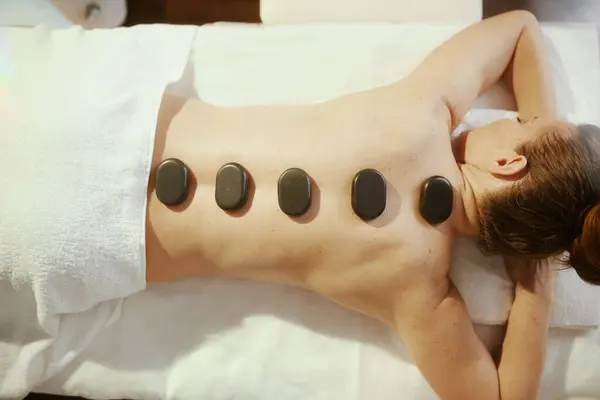Gesundheitszeit Entspannte Moderne Frau Massagekabinett Mit Hot Stone Massage Und Stockbild
