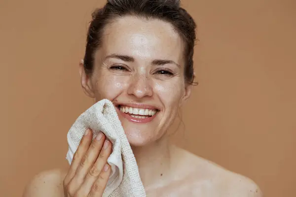 Sorridente Donna Mezza Età Con Asciugamano Viso Lavaggio Contro Sfondo Immagine Stock