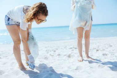 Deniz kıyısındaki çöp torbalarıyla ilgilenen çevreci aktivistler..