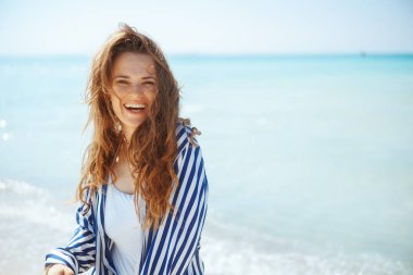 Gülümseyen modern kadın deniz kenarında eğleniyor..