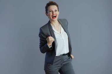 Kırk yaşında zarif bir gülümseme. Gri takım elbiseli küçük bir işletme sahibi. Gri renkli bir elbisesi var..