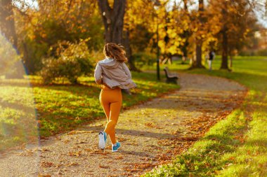 Merhaba sonbahar. Parkta spor kıyafetleriyle koşan modaya uygun bir kadın gördüm..