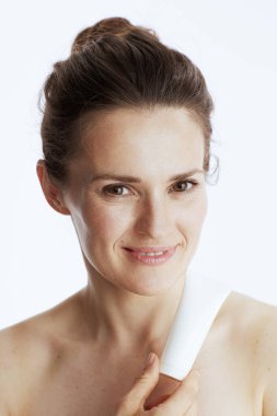 Beyaz tenli kozmetik krem kavanozlu gülümseyen genç bir kadın..