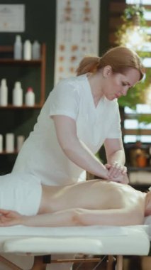 Sağlık hizmeti zamanı. Masaj dolabında masaj terapisti müşterilerine masaj yapıyor..