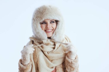 Beyaz eldivenli, kürk şapkalı, kışlık ceketli mutlu orta yaşlı kadın..