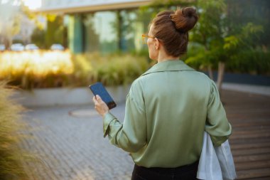 Ofis binasının yanında çalışan, yeşil bluzlu, akıllı telefonlu bir kadın tarafından görülmüş..
