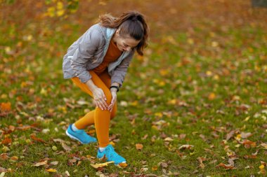 Merhaba sonbahar. Parkta dizinde ağrı olan orta yaşlı, üzgün bir kadın..
