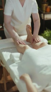 Sağlık hizmeti zamanı. Masaj kabinindeki masaj terapistine yakın çekim. Masaj masasına ayak masajı yapan müşterilere..