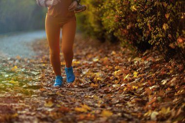 Merhaba sonbahar. Parkta koşan spor elbiseli bir kadına yaklaş..