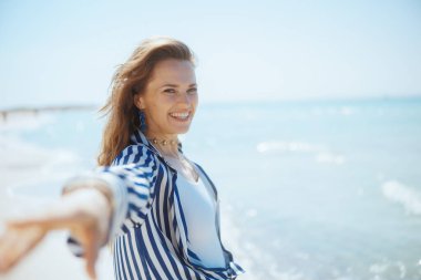 Mutlu orta yaşlı kadın okyanus kıyısında eğleniyor..