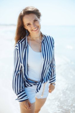 Mutlu orta yaşlı kadın okyanus kıyısında eğleniyor..