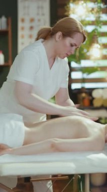 Sağlık hizmeti zamanı. Masaj kabinindeki masaj terapistine yakın çekim yap ve terapi amaçlı masaj yap..