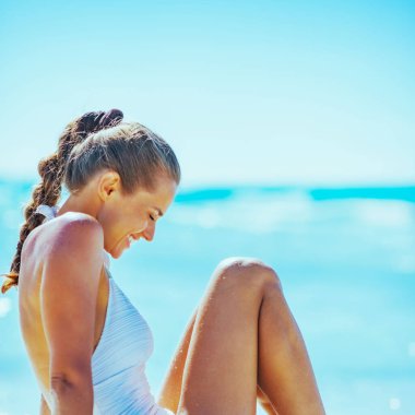 Sahilde oturan genç kadın