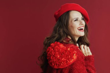 Mutlu Sevgililer. Kırmızı kazaklı ve bereli, kırmızı kalpli, güler yüzlü bir kadın..