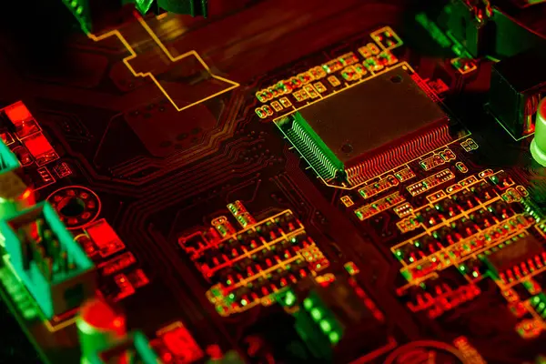 Kırmızı ve yeşil ışıkla aydınlatılan devreleri ve mikroçipleri olan bir anakart, geleceksel ve teknolojik bir atmosferi iletiyor..