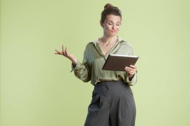 Bir kadın tablet üzerinde şüpheci bir ifadeyle çalışıyor, belki de ekranda gördüğü bilgiyi sorguluyor..