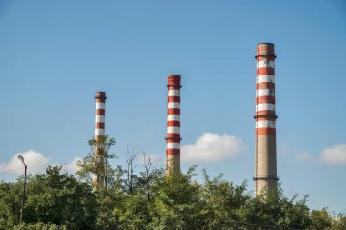 Mavi gökyüzü arka planında termik santralin bacaları