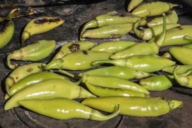 Çiftlik evindeki ateş çukurunda kavrulmuş yeşil biber.