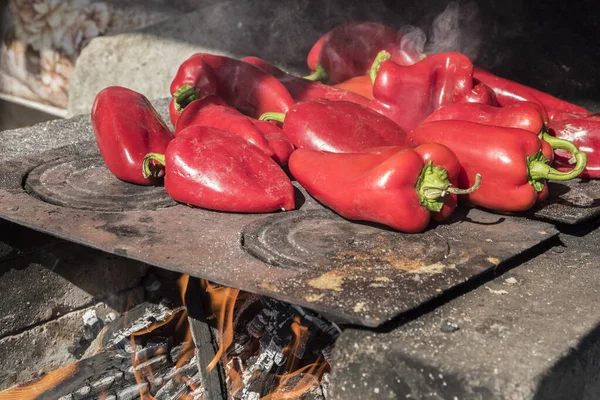 stock image Roasting red bell peppers on outdoor fire pit of farmhouse