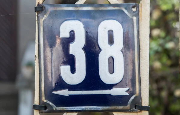 Weathered grunge square metal enameled plate of number of street address with number 38