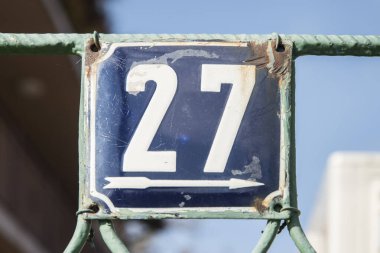 Yıpranmış, köhne, metal plakalı, 27 numaralı sokak adresi.