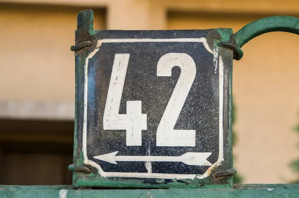Weathered grunge square metal enameled plate of number of street address with number 42