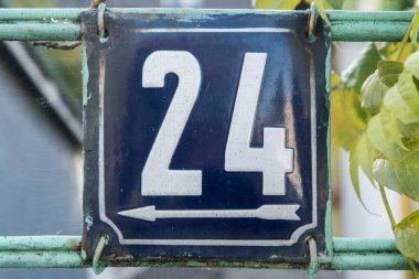 Yıpranmış 24 numaralı sokak adresinin plakası işlemeli eski kare metal.