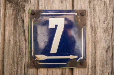 Yıpranmış 7 numaralı sokak adresinin plakası işlemeli eski kare metal.