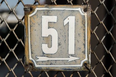 Yıpranmış grunge kare metal işlemeli sokak adresi plakası. Beyaz arka planda 51 numara izole edilmiş.
