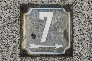 Yıpranmış 7 numaralı sokak adresinin plakası işlemeli eski kare metal.