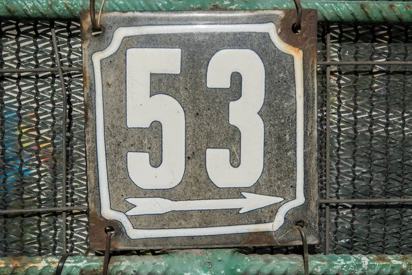 Weathered grunge square metal enameled plate of number of street address with number 53