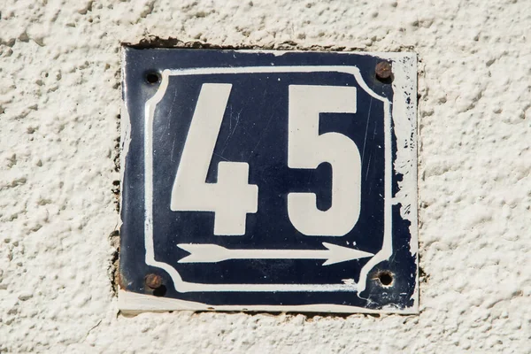 Weathered grunge square metal enameled plate of number of street address with number 45