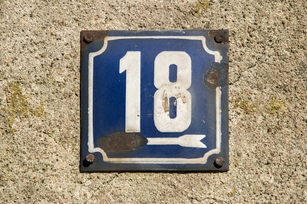 Weathered grunge square metal enameled plate of number of street address with number 18