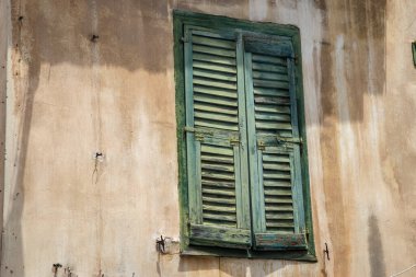 Eski Akdeniz evinin ön cephesinde ahşap panjurlu pencereler