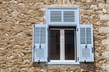 Eski Akdeniz evinin ön cephesinde ahşap panjurlu pencereler