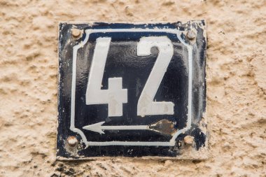 Yıpranmış kare metal plaka numarası 42 olan sokak adresi.