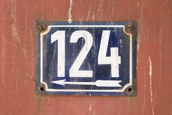 Weathered grunge square metal enameled plate of number of street address with number 124