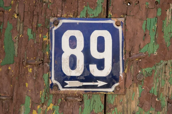 Weathered grunge square metal enameled plate of number of street address with number 89