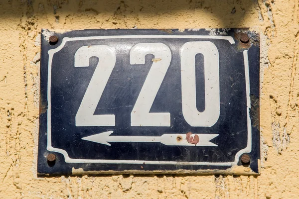 Weathered grunge square metal enameled plate of number of street address with number 220