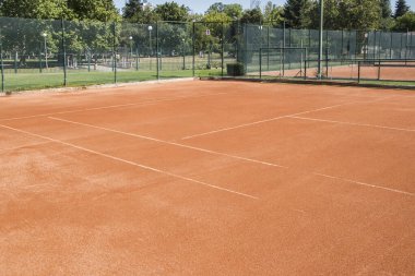 Kırmızı kil kort yüzeyi tenis kompleksine yakın.