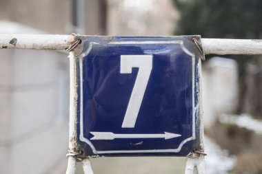 Yıpranmış 7 numaralı sokak adresinin plakası işlemeli eski kare metal.