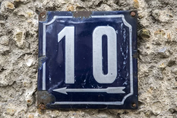 Weathered grunge square metal enameled plate of number of street address with number 10 isolated on white background