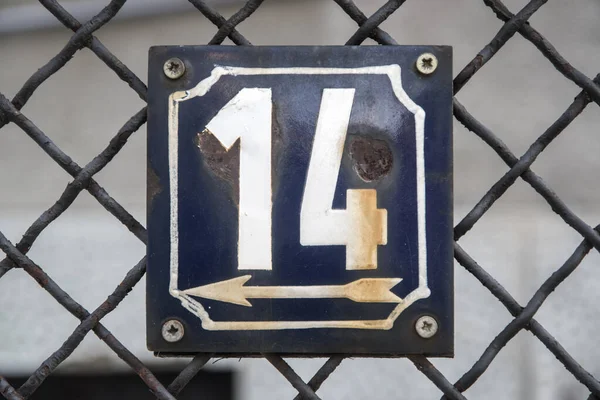Weathered grunge square metal enameled plate of number of street address with number 14