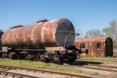 Paslı, terk edilmiş petrol tankerleri güneşli bir günde bir tarlanın ortasında