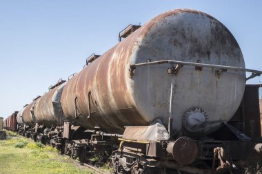 Paslı, terk edilmiş petrol tankerleri güneşli bir günde bir tarlanın ortasında