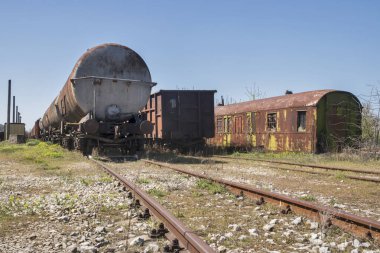 Paslı, terk edilmiş petrol tankerleri güneşli bir günde bir tarlanın ortasında