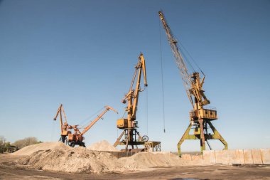 Açık güneşli bir günde Nehirdeki sanayi turnaları yükleme deposunu boşaltıyor